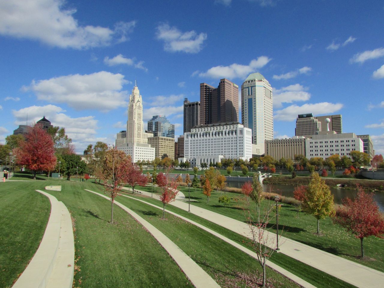 Columbus skyline beyond a riverside park on a sunny day