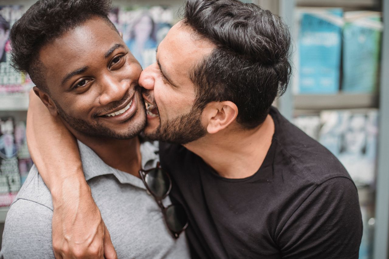 Man kissing his smiling partner on the cheek