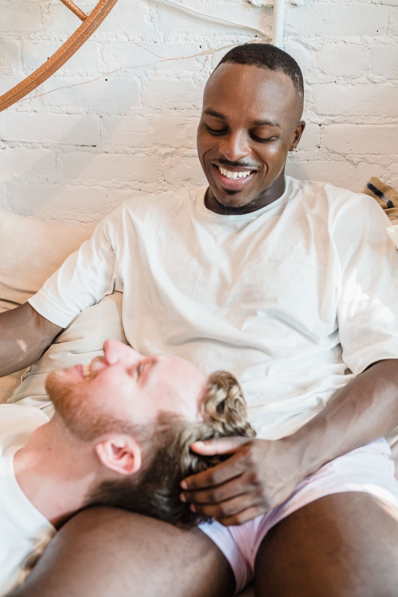 Man resting his head in his smiling partner's lap