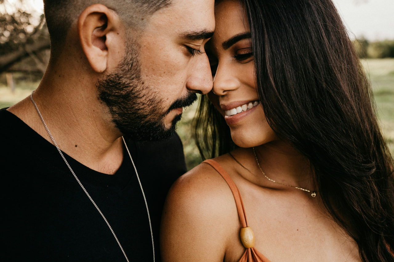 Mujer colombiana sonriente apoyada en su pareja al aire libre — citas colombianas