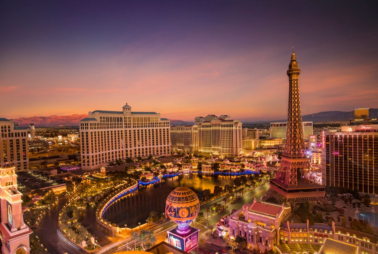 Las Vegas Strip at dusk with the Bellagio fountains and the Eiffel Tower replica