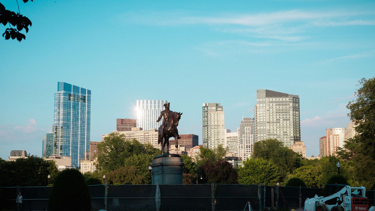 Boston skyline behind an equestrian statue in a park
