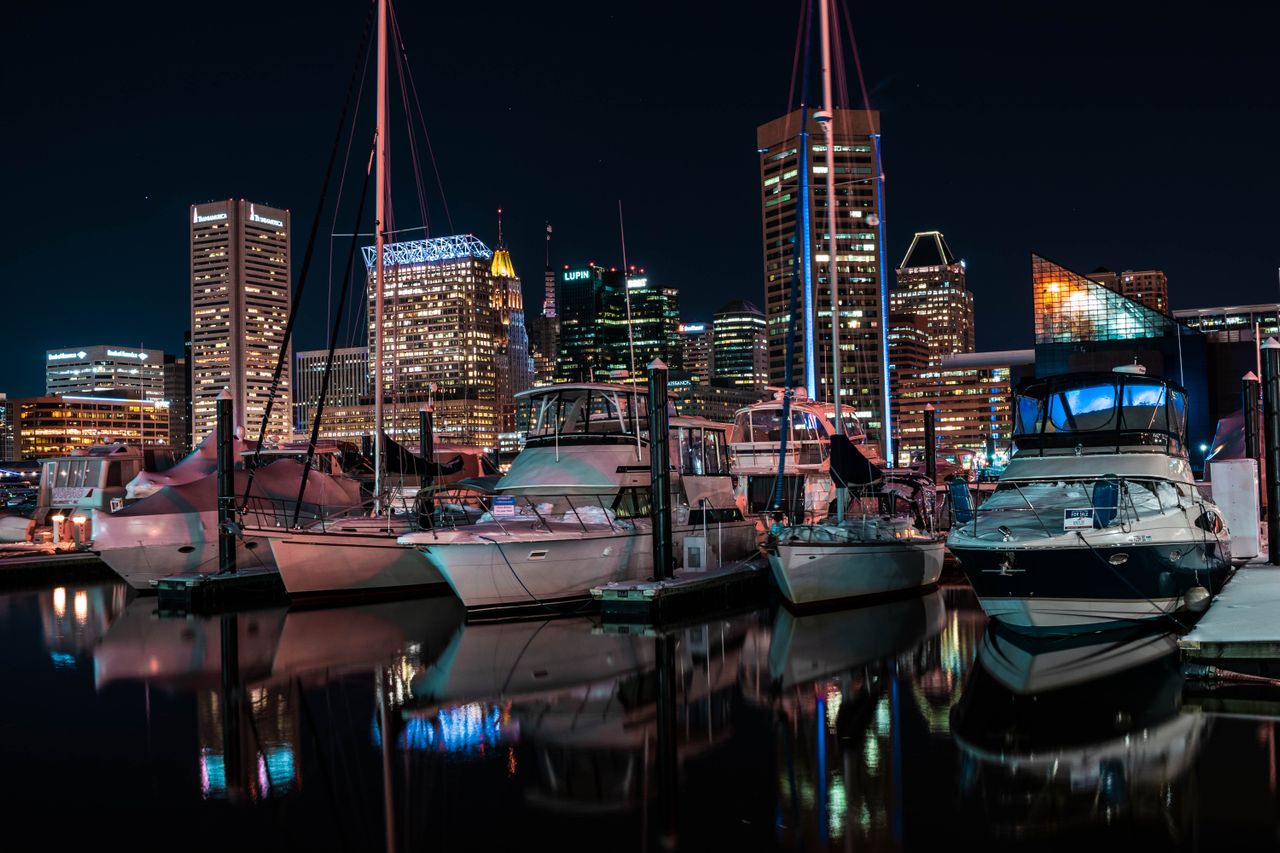 Boats in the Inner Harbor marina with Baltimore's towers lit up at night