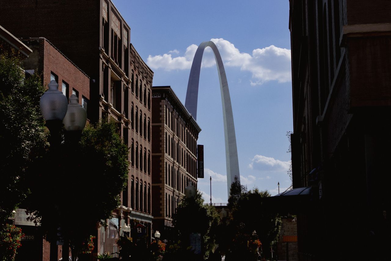 Gateway Arch in St. Louis seen between brick buildings