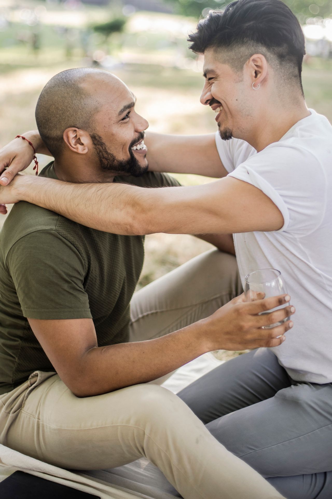 Two men hugging and smiling outdoors