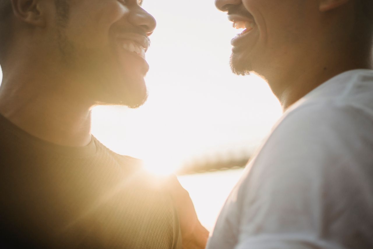 Two men smiling at each other in warm sunset light