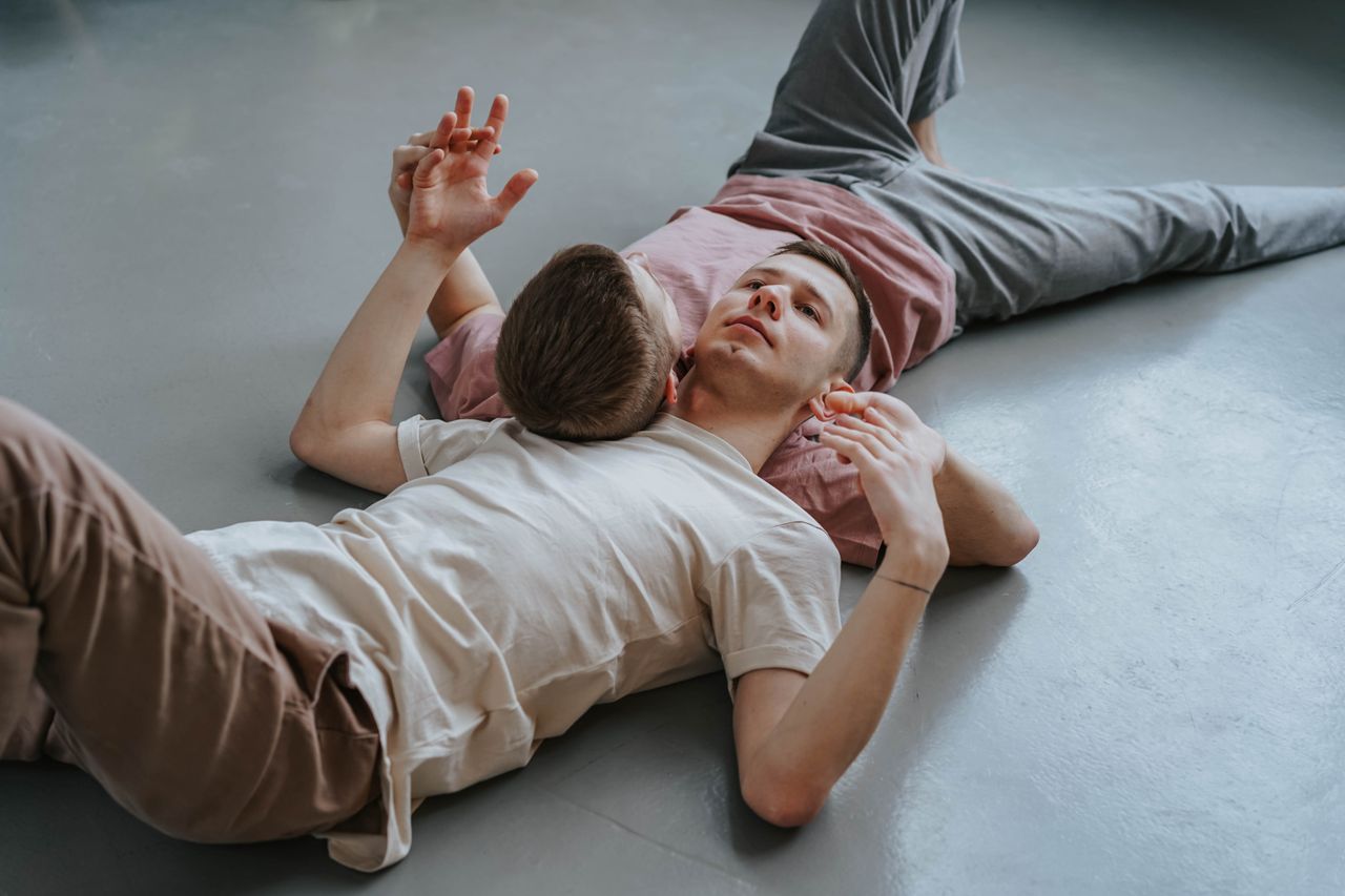 Two men lying on the floor and laughing together