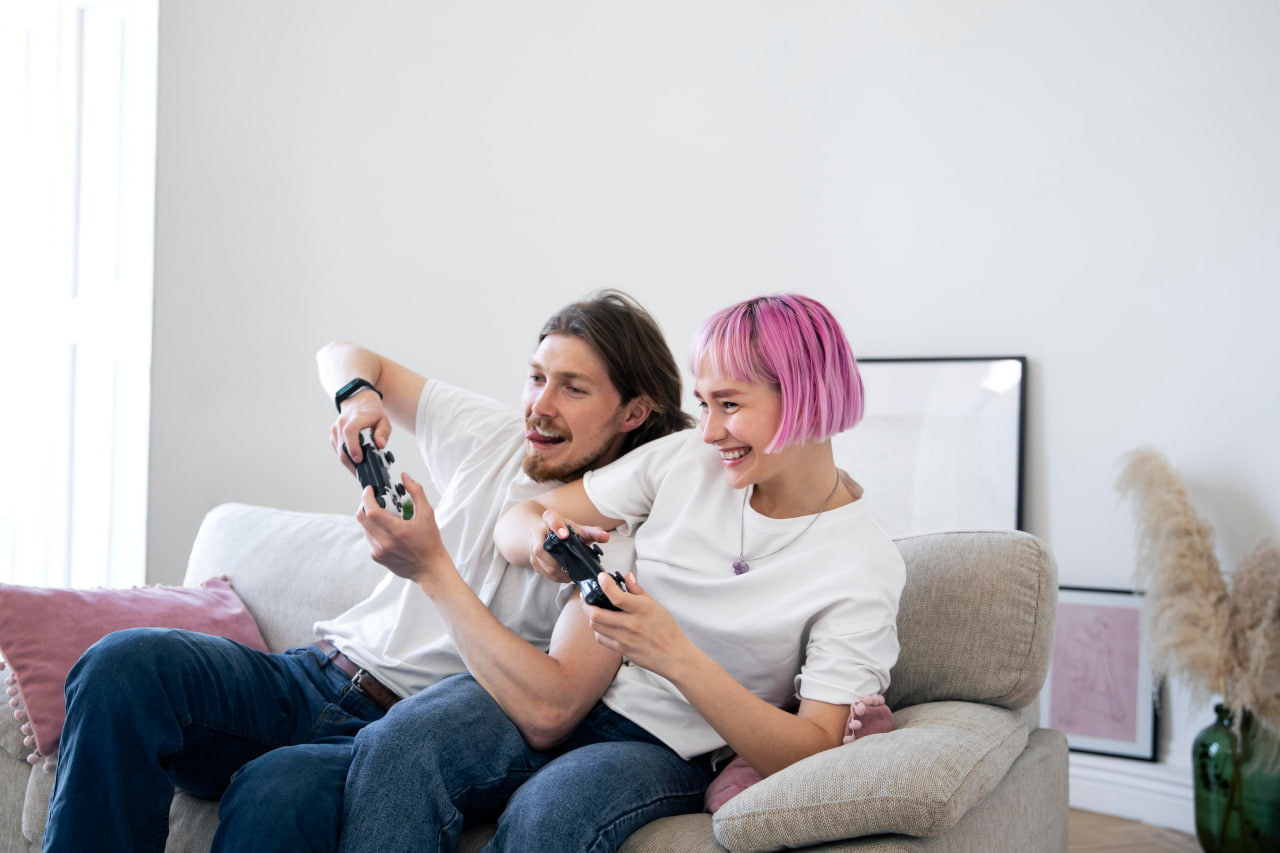 Young couple with controllers enjoying a session at home, found through a gaming dating app.