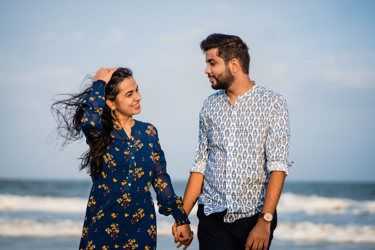 Happy couple holding hands on the beach, showcasing the romance of dating indian women.